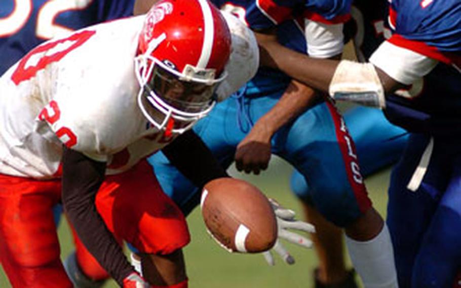 From left, Kaiserslautern’s Rashawn Williams, and Ramstein’s Cyril Borden and Greg Anderson scramble for a loose ball after Anderson fumbled during a Division I football semifinal in Ramstein, Germany, on Saturday. Williams recovered the fumble, but Kaiserslautern lost 39-7.