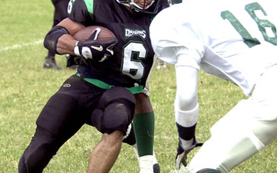 Kadena Dragons running back Isaac Warren (6) looks for running room between Courtney-Hansen Titans defenders Andre Morgan (16) and Vedel Poindexter, rear, during Saturday’s game at Camp Foster, Okinawa.