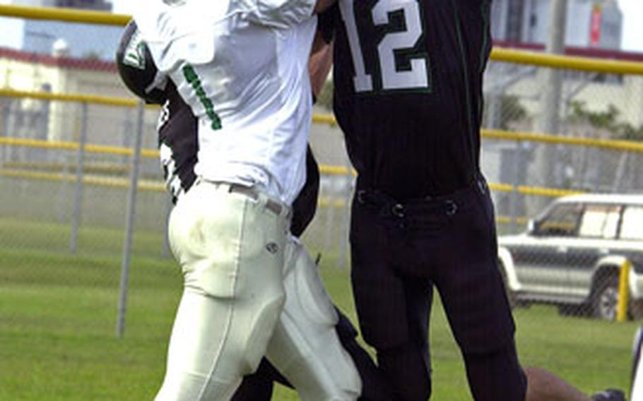 Kadena Dragons safety Michael Soster, right, intercepts a pass intended for Courtney-Hansen Titans receiver Trevor Highsmith.