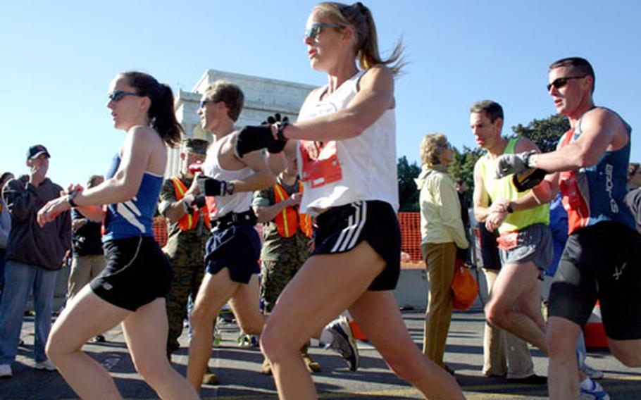 Runners check their splits as the pass the 10-mile mark at the Lincoln Memorial during in Sunday&#39;s Marine Corps Marathon.