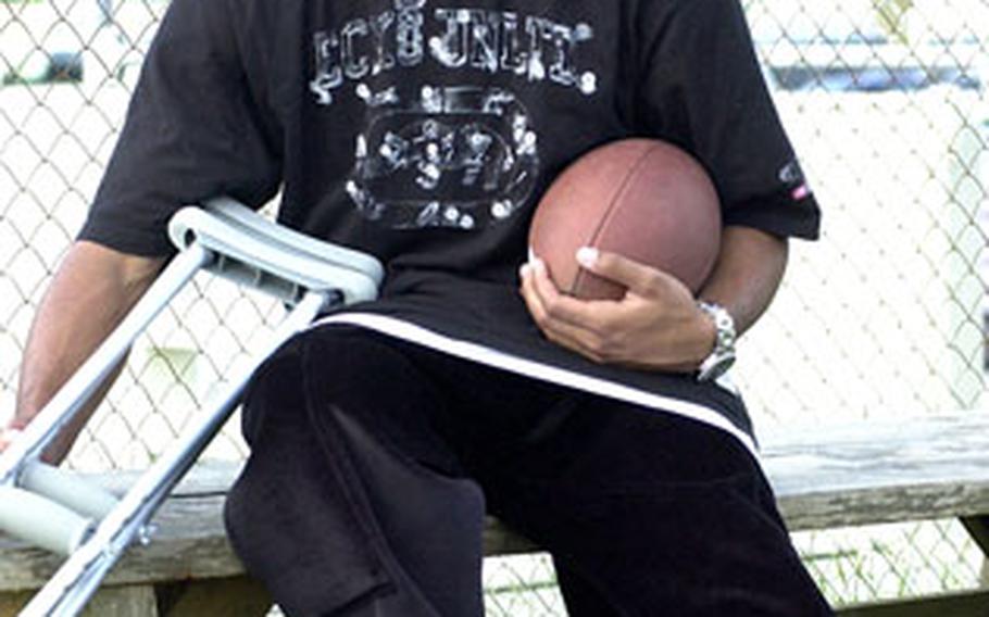 Kubasaki senior tight end/linebacker Stephen Thompson watches his teammates from a bench during Monday’s practice at Upper Field, Kubasaki High School, Camp Foster, Okinawa. Thompson suffered a season-ending ankle injury.