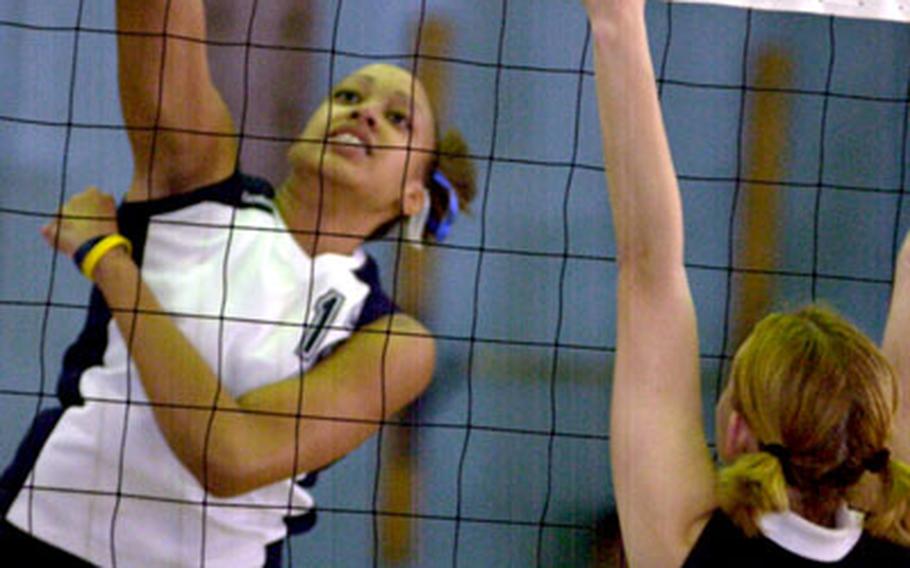 Seoul American senior middle blocker Margaret Nurse, left, spikes past senior Kat Schultz of Zama American during Thursday's first-round playoff match. Seoul American beat Zama American 25-21, 20-25, 25-11, 25-16.