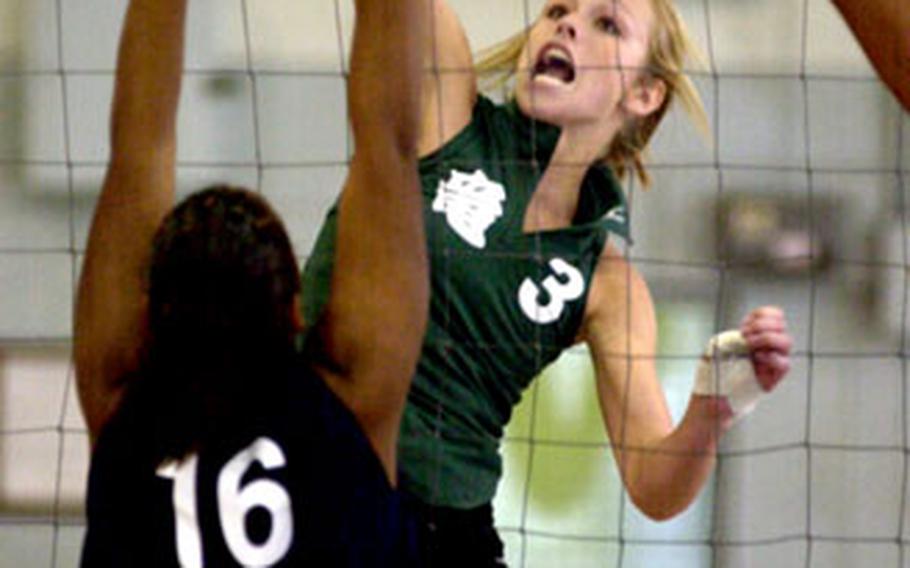 Kubasaki Dragons senior middle blocker Alex Fernandez (3) hammers the winning spike kill past sophomore Erica Anglade of the Seoul American Falcons during Friday’s Class AA quarterfinal at Yongsan Garrison, South Korea. The Dragons won 25-21, 19-25, 25-14, 19-25, 15-12.