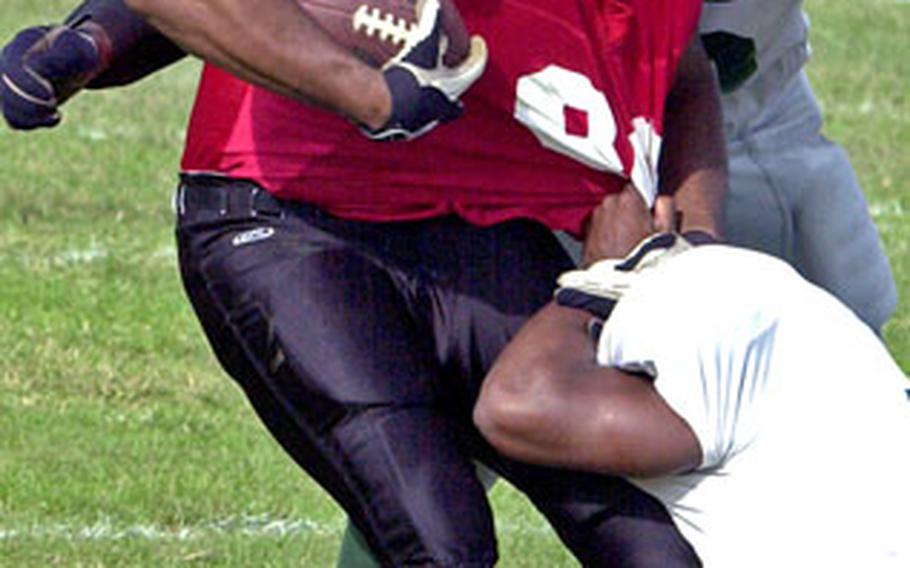 Foster-Futenma tight end Brandon Ledet has his jersey pulled as he’s corralled by Courtney-Hansen Titans defenders Donald Jackson and Frank Mbanusi.