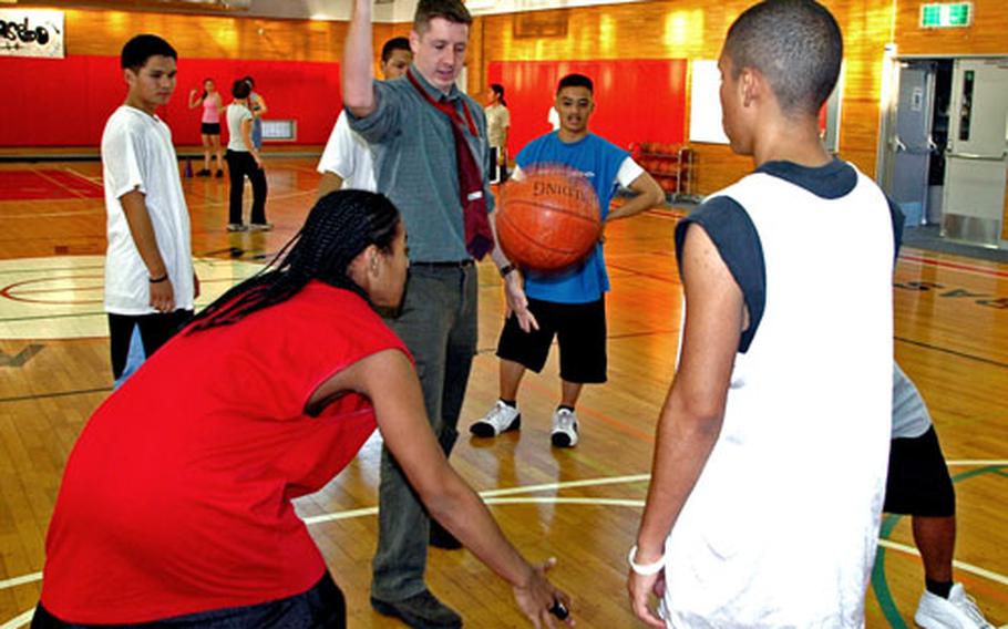 E.J. King boys basketball coach Daren Schuettpelz conducts a drill Tuesday in the school gym at Sasebo Naval Base, Japan.