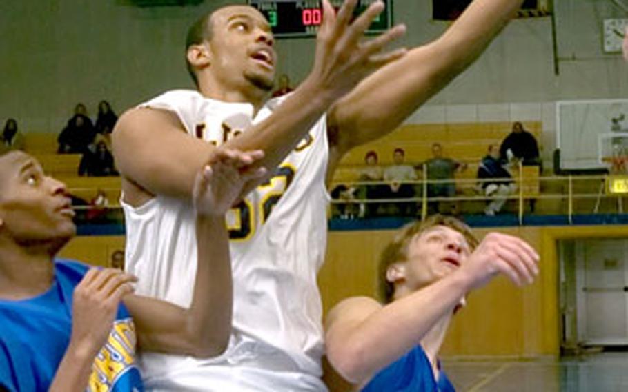 Heidelberg’s Damon Fleming splits the defense of Wiesbaden’s Anthony Smith, left, and Chase Socha on Friday. Fleming had 31 points and 20 rebounds.