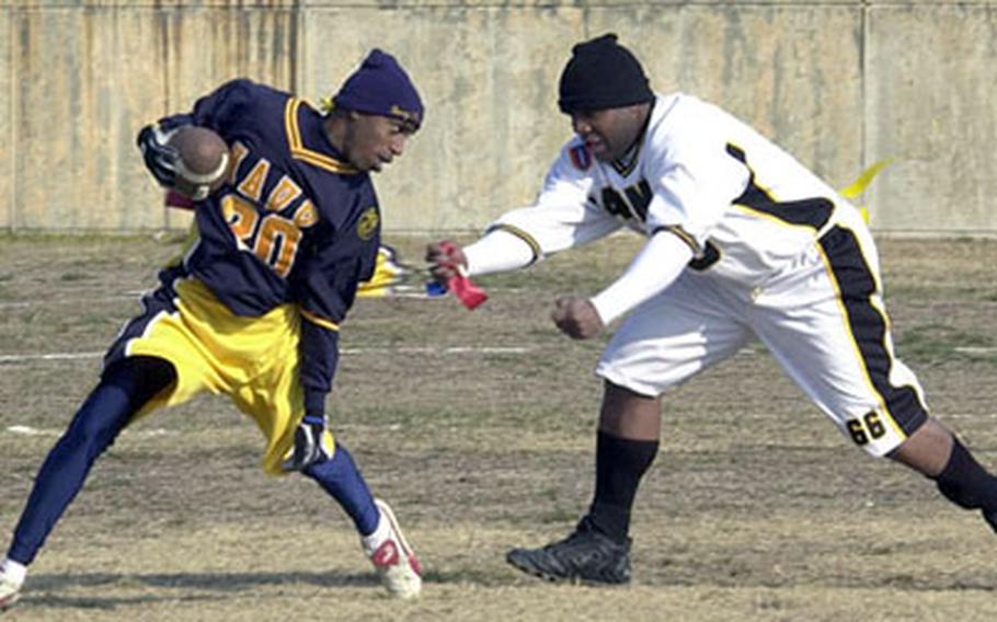 Navy runner Robert London, left, attempts to shake an Army defender during Saturday’s Army-Navy flag football game at Yongsan Garrison, South Korea. Army won 12-6, part of a three-game sweep by soldiers of Army-Navy games at Yongsan, Torii Station on Okinawa and Camp Zama, Japan.