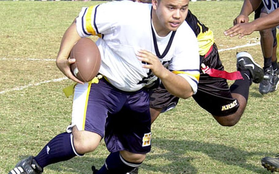 Navy running back Ricky Carino tries to elude Army defender Perrie Williams during Saturday’s Army-Navy flag football game at Torii Station, Okinawa. Army routed Navy 27-3.  for more photos from Okinawa.