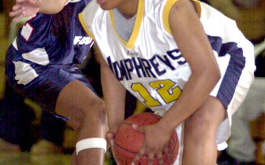 Sophomore Alysia Gray of the Seoul American Falcons defends as Kenoshie Lilly of the Camp Humphreys Bulldogs looks to pass during Monday&#39;s round-robin play. Seoul American won, 67-57.