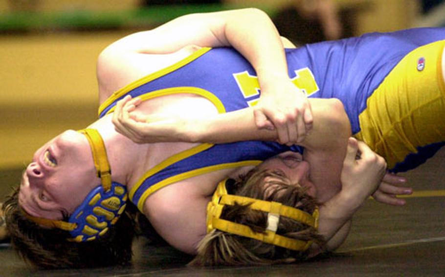 Yokota’s Andrew Conkling arches his head back and uses a head-in-arm hold to push the shoulders of David Budge of the American School In Japan Mustangs to the mat during Wednesday’s 158-pound bout.