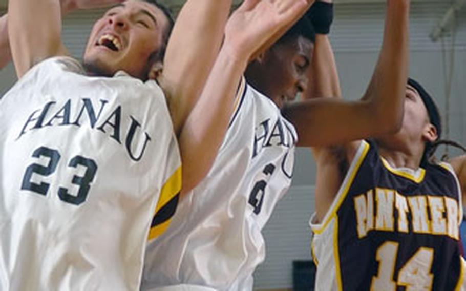 Hanau’s Darren Mickens grabs a rebound between teammate Ivan James and Patch’s Carey Williams on Friday night in Hanau, Germany. Hanau defeated Patch 58-44.