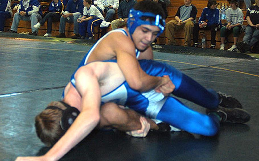 Johnathan Scott, top, clamps a hold on Mike Zupi of Brussels American High School during the regional tournament at Alconbury High School Feb. 11. Scott, a two-time defending European wrestling champ from London Central High School, finished first in the tournament; Zupi finished third.