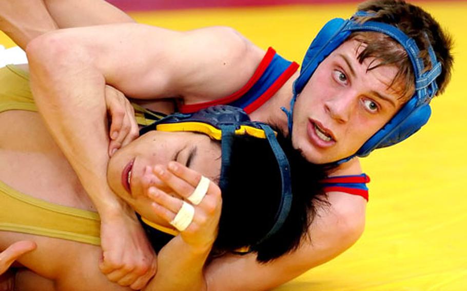 Ramstein’s Noah Sheppard tries to get Heidelberg’s Andrew Moon in a headlock during the 125-pound championship match, wich Sheppard won 11-2.