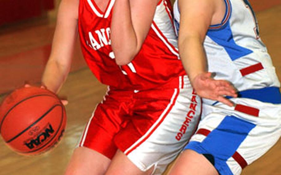 Lakenheath’s Greta Gerstner drives against Lydia Grey of International School of Brussels in a Division I tournament game. Second seed ISB beat the third-seeded Lancers, 40-27.