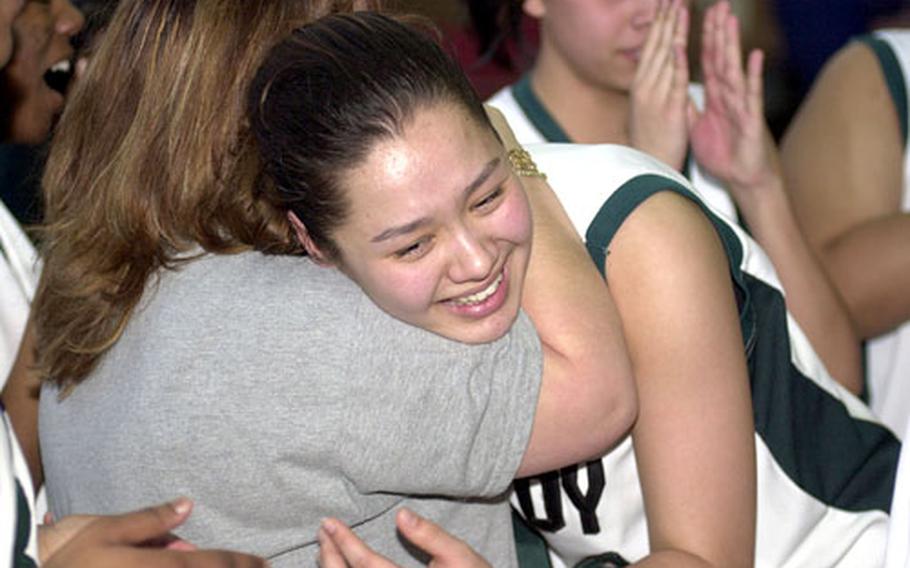 Taegu American senior center Kelli Cox gets a hug from coach Michelle Chandler after Thursday&#39;s win over Faith Academy.