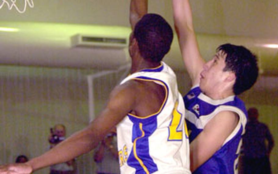 Seoul American’s Andrew Luna, right, puts up a shot just out of Yokota’s Caiveon Thomas.