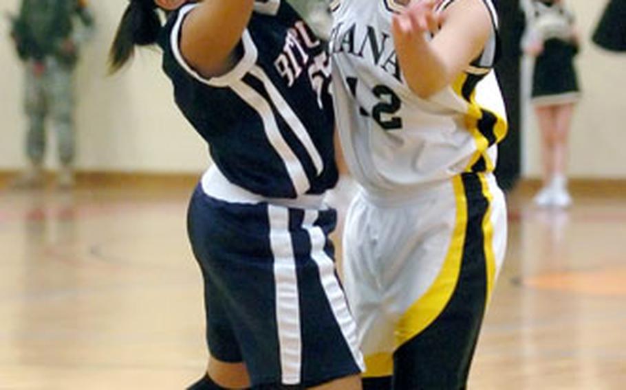 Bitburg’s Melissa James, left, blocks a pass by Hanau’s Feiloaiga Oloi during the DODDS Europe Division II girls championship in Mannheim, Germany, on Saturday night. Bitburg upset top-seeded Hanau 45-31 to win the title.