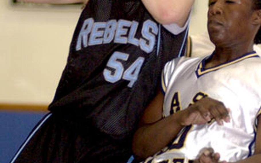 Yongsan Runnin’ Rebels guard Robin Ferguson (54) drives to the basket and is fouled by Kimberly Sinclair of the 2nd Infantry Division Warriors during the first of two women’s championship games in the Kadena Klassic. Yongsan beat 2nd ID 64-47 and 57-52 to win the tournament.