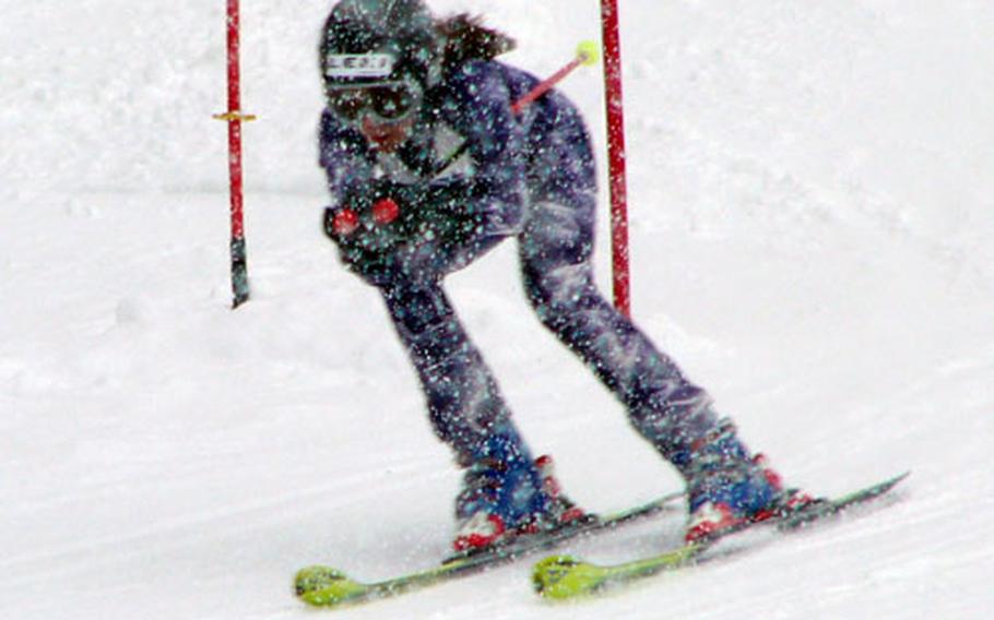 Joyce Ellis, 11, of Garmisch, Germany, masters a snowstorm and the next-to-last gate on the course Saturday during her second run at the U.S. Forces Europe youth giant slalom championship at Garmisch. Ellis, whose older sister Kristin, 15, skied the fastest time of the day -1:26.51 - posted by any skier of any age or sex, clocked a two-run time of 1:31.79 to win the girls&#39; junior event for skiers aged 10-12.