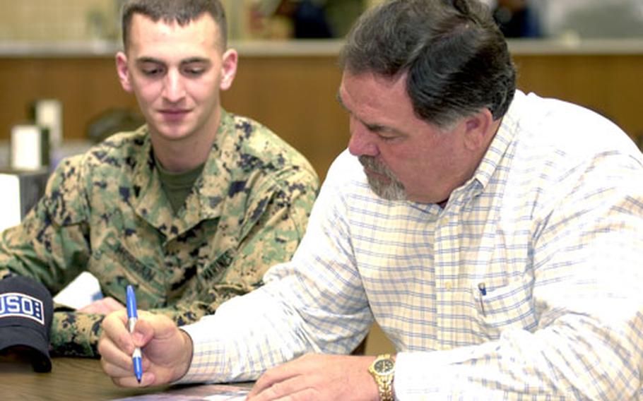 Ron Swoboda signs a photograph of himself from his playing days for Cpl. Jason Morgan, 21, of Corning, N.Y., during a Thursday visit to the USO on Camp Schwab, Okinawa. Swoboda visited four Okinawa-based USO outlets, at Camps Schwab and Hansen, Futenma Marine Corps Air Station and Kadena Air Base to meet troops, sign autographs and talk baseball. The visits were part of a one-week tour of the island by Swoboda, on behalf of the USO in support of Special Olympics on Okinawa.