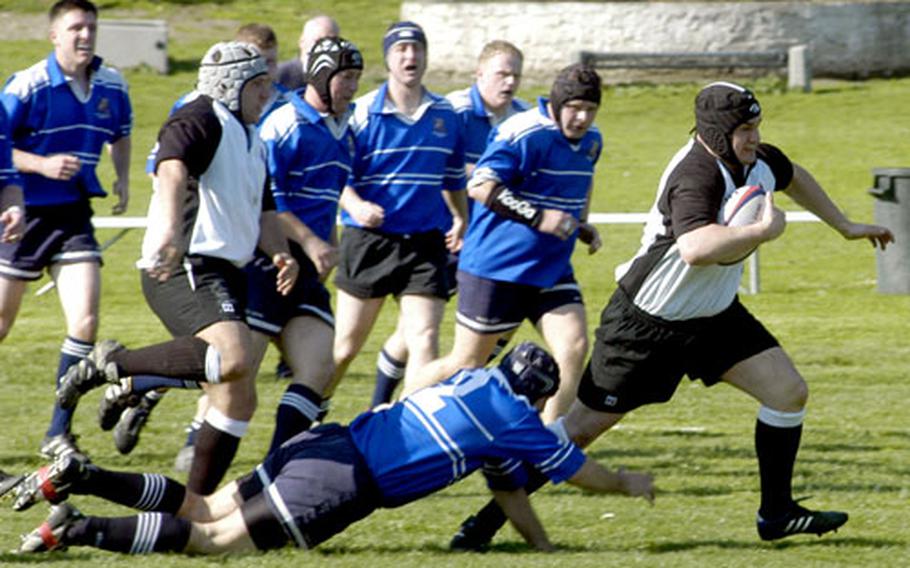 Joshua Henderson of the U.S. Forces Europe team tries to pull away from NATO defenders during the first half of their rugby match Friday at Carney Park in Naples, Italy. NATO beat the U.S. military team 15-7.