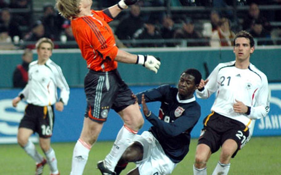 German goalie Oliver Khan and U.S. forward Eddie Johnson converge on a long, bouncing shot toward the end of Germany’s 4-1 win over the U.S. on Wednesday in Dortmund. The ball, kicked by U.S. defender Steve Cherundolo, bounced into the goal for the only U.S. score.