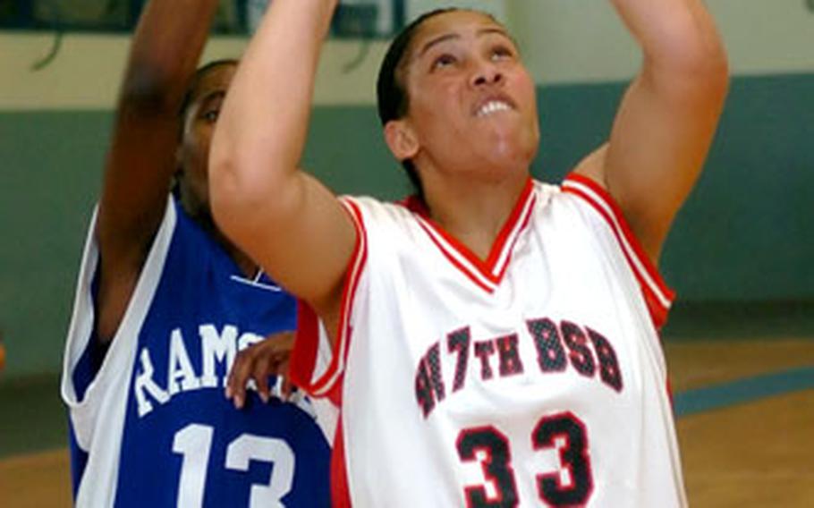 Kitzingen’s Bertha Kabaye scores two in the paint against Ramstein’s Cheryl Burney during the final game of the Army/Air Force Final Four basketball tournament in Kaiserslautern, Germany, on Sunday.