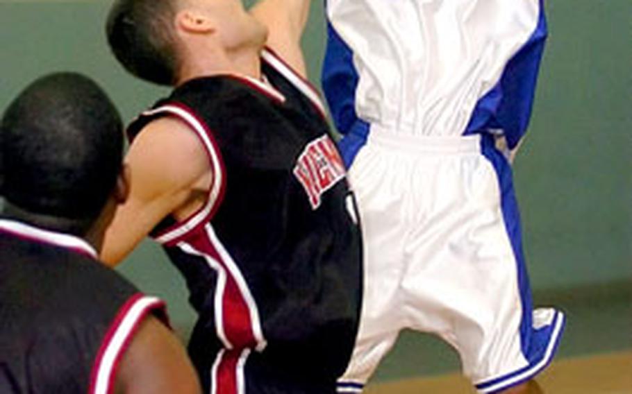 Wiesbaden’s Deon Pearman shoots a three-pointer over Mildenhall’s Jason Ramos.