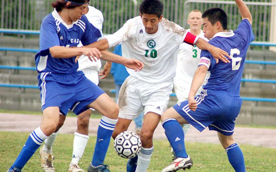 Kubasaki’s Chris Monroy, center, fights for the ball against two players from Christian Academy In Japan during Thursday’s semifinal match in the Far East Boys Class AA Soccer Tournament. Kubasaki won 5-1 and will play Kadena for for the fifth time this season, this time with a championship on the line.