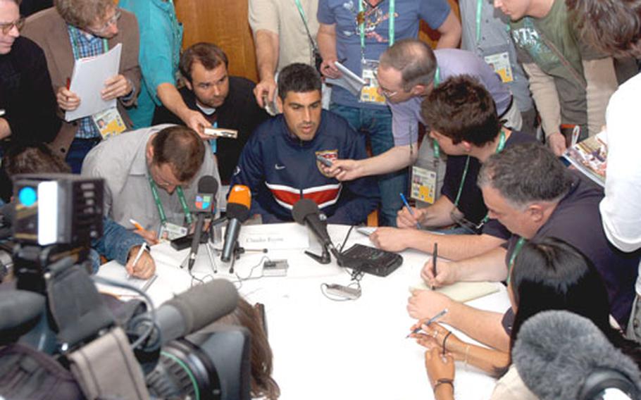 Claudio Reyna, captain of the U.S. men&#39;s soccer team, is besieged by reporters during a press conference Friday at the Park Hyatt Hotel in Hamburg, Germany.