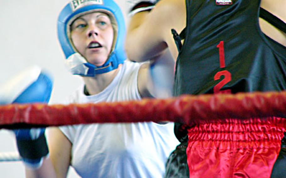Chandra LeCompte of Ramstein sticks a jab into the face of Bamberg’s Mona Michelson during the U.S. Forces Europe women’s light middleweight championship bout Sunday at Wiesbaden Army Airfield, Germany. LeCompte won with a second-round stoppage.