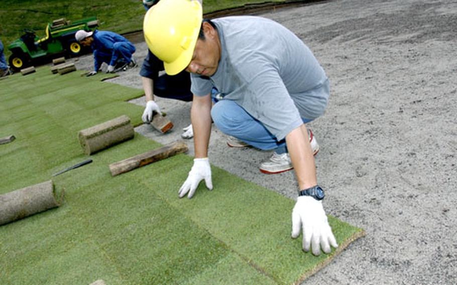 Japanese workers lay sod Monday on the No. 10 putting green at Gosser Memorial Golf Course at Misawa Air Base, Japan. The hole is being redesigned to meet U.S. Golf Association standards.