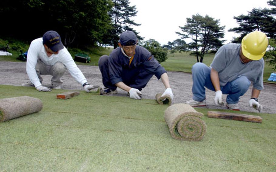 Japanese workers lay sod Monday on the No. 10 putting green at Gosser Memorial Golf Course at Misawa Air Base, Japan. The hole will reopen in mid-July or early August.