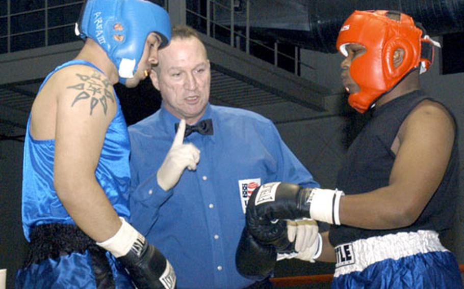 Referee Sgt. 1st Class Charles Ryan goes over the rules before a Feb. 18 light-heavyweight bout between Staff Sgt. Rene “Lando” Aleman, left, of Camp Stanley, and Sgt. Michael Carroll of Camp Carroll.