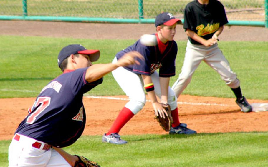 Ramstein pitcher Finn Harrington delivers Saturday in Kutno, Poland, as first baseman Matthew Lynch and Brussels baserunner Riku Iishe, who had just singled sharply to right, await developments. Brussels, run-ruled 13-0 Friday by six-time defending champion Saudi Arabia, rebounded to even its record in the Little League Europe Region&#39;s Transatlatic Regional round-robin tournament with a 6-3 victory to even its mark at 1-1. Ramstein, which downed Naples 8-6 in its opener on Friday night, fell to 1-1.