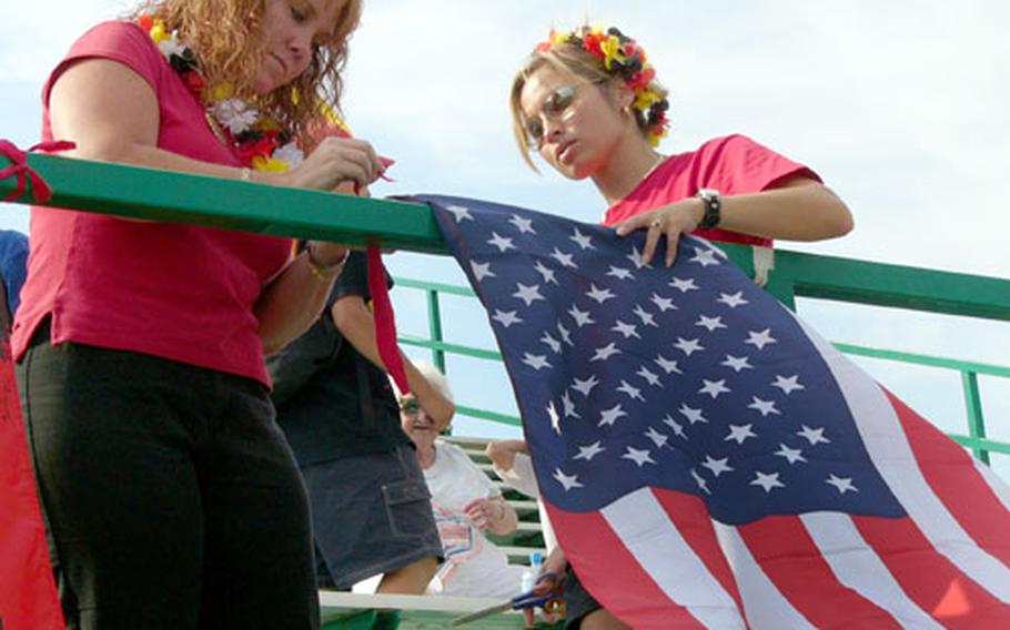 Ramstein supporters Robin Ortiz, left, and Chintana Burns hang out the colors Friday prior to their team&#39;s opening game in the 2006 Littlle League European Regional Transatlantic Tournament at Kutno, Poland. Ramstein was taking on Naples in its first round-robin game in this six-day event, which sends the winner to the Little League World Series at Williamsport, Pa.