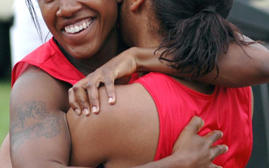 Melanie Middlebrooks, left, and Tasia Pittman of Spangdahlem celebrate after the women&#39;s 100-meter dash. Pittman won the race with a time of 14.25 seconds and Middlebrooks came in second at 14.47.