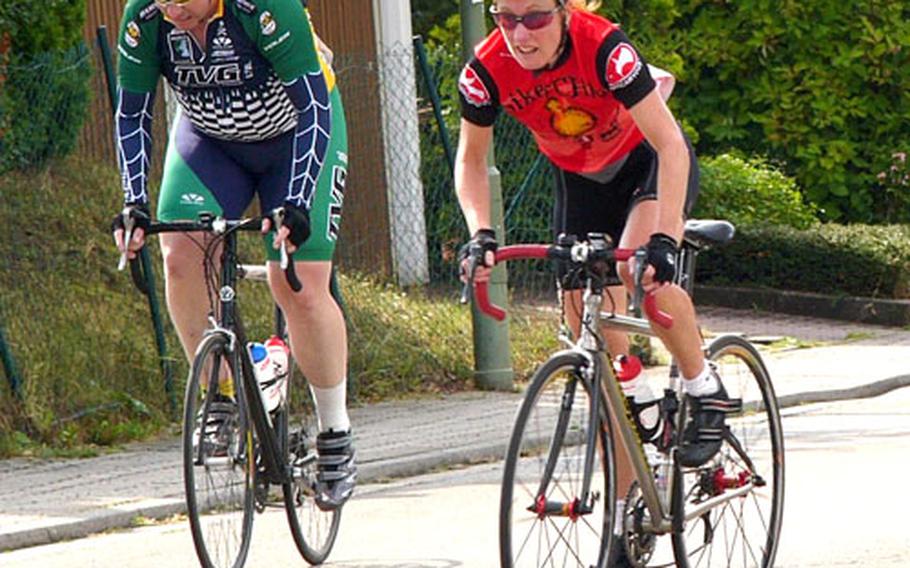 Women&#39;s champion Ursula Cunneen of Spangdahlem powers past men&#39;s masters&#39; rider Shelley Joseph of Mannheim during Saturday&#39;s U.S. Forces Europe road cycling series race at the Kaiserslautern, Germany, suburb of Dansenberg.
