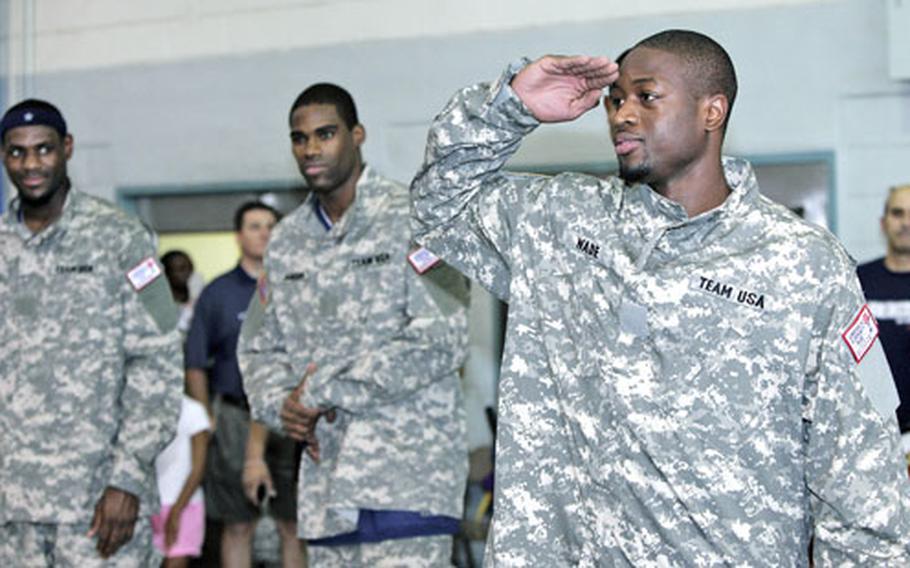 Dwyane Wade of Team USA offers a hand salute as he and other members of the squad arrive at the Yongsan Garrison gymnasium for a practice session Monday.