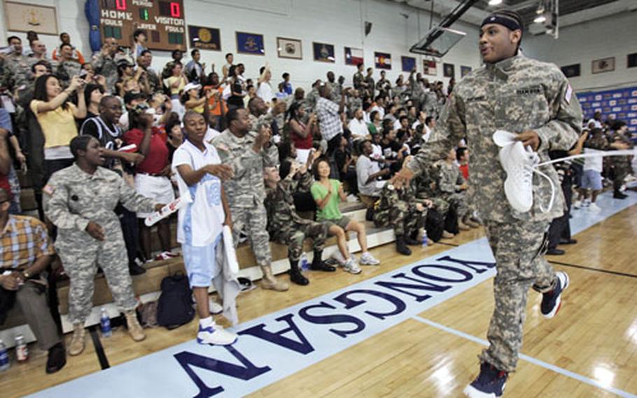 Team USA’s Camelo Anthony, right, enters the Yongsan Garrison gymnasium wearing an Army combat uniform on Monday.