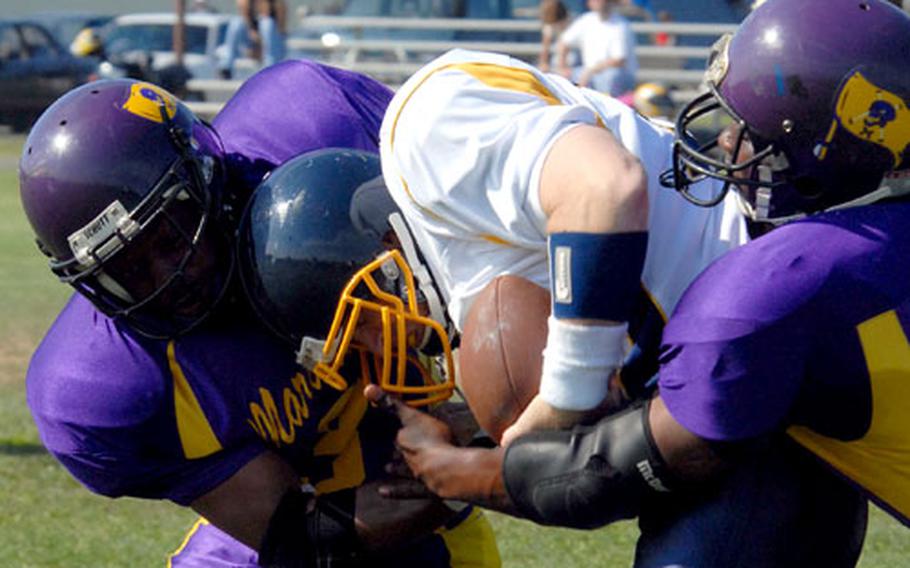 Yokota Warriors quarterback Jay McNulty gets corraled by Misawa Marauders defenders Jervis Byers and LeRoy Moody during Saturday’s UUSFJ-AFL semifinal at Misawa Air Base, Japan.