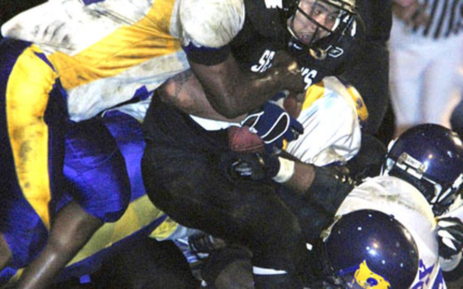 Yokosuka Seahawks fullback Alex Ladera gets corraled by Leroy Moody, left, and Mark Fox of the Misawa Marauders during Friday’s USFJ-AFL championship Torii Bowl at Berkey Field, Yokosuka Naval Base, Japan. Yokosuka blanked Misawa 12-0 for its fourth Torii Bowl title.