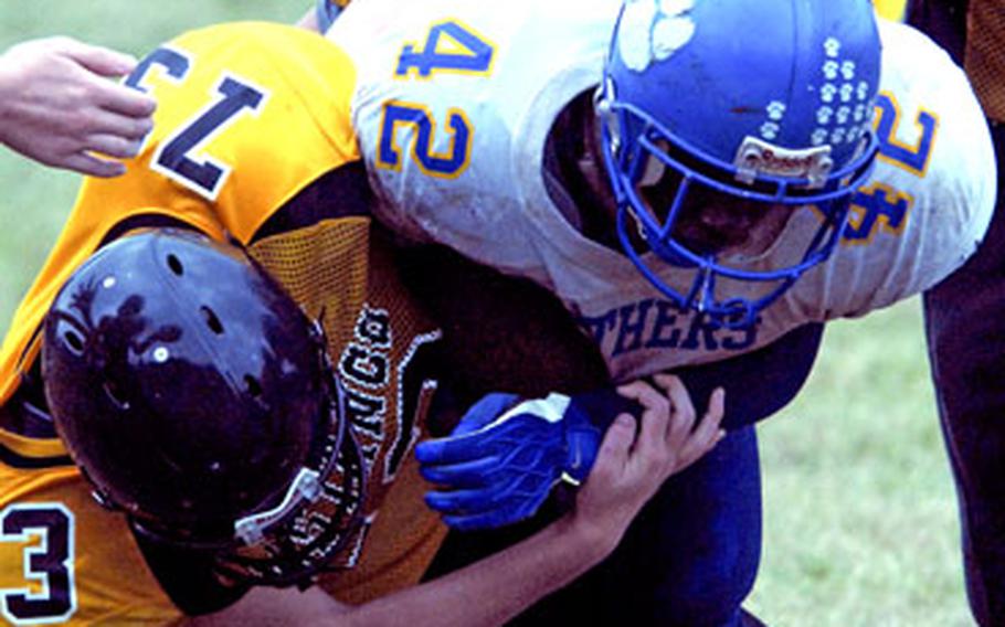 Yokota Panthers running back Anthony McNeill (42) lunges through the tackle of Joey Benus (50) and David Zielinski (73) of the American School In Japan Mustangs during Saturday’s game at Mustang Valley, American School In Japan’s Chofu campus in Tokyo’s western suburbs.