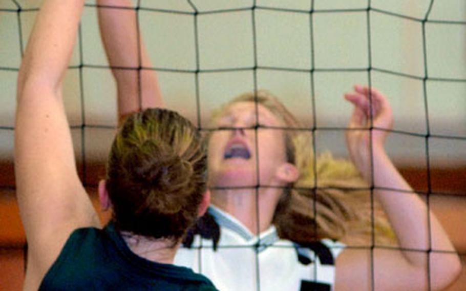 Kubasaki middle blocker Sarah Brubaker (15) and Helen Schrock (5) of Kadena battle for the ball during Wednesday's Okinawa Activities Council girls volleyball season-opening match. Kubasaki rallied to win 23-25, 18-25, 25-10, 25-12, 16-14.