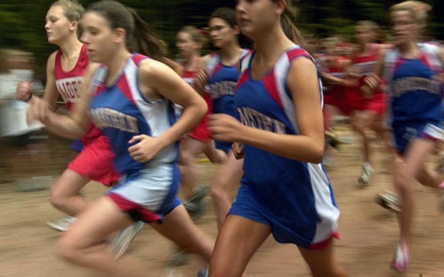 Colleen Smith, left, the returning European champ from Kaiserslautern High School, pushes off the starting line amid a sea of runners during the first cross country race of the season in Vogelweh, Germany, on Saturday.