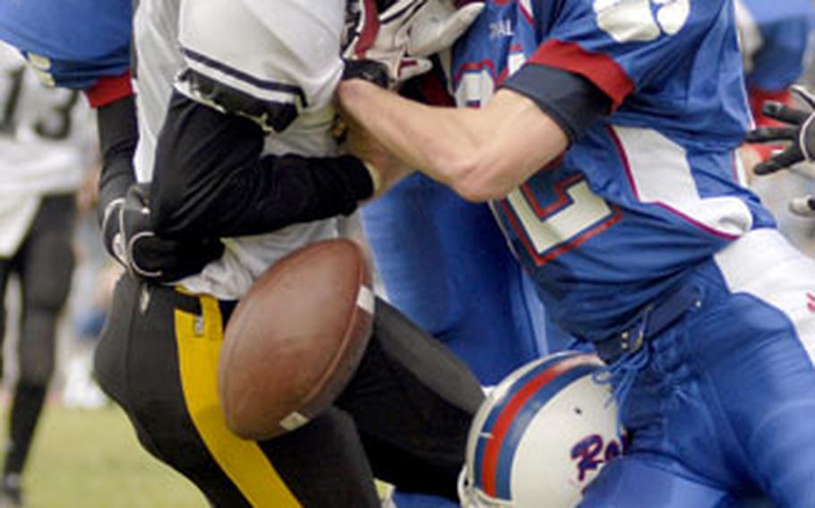 Scott Sublousky, right, strips the ball from Patch rusher Diego Cruz during the first half of Ramstein’s 41-20 victory Saturday. Ramstein is the only undefeated team in Europe Division I.