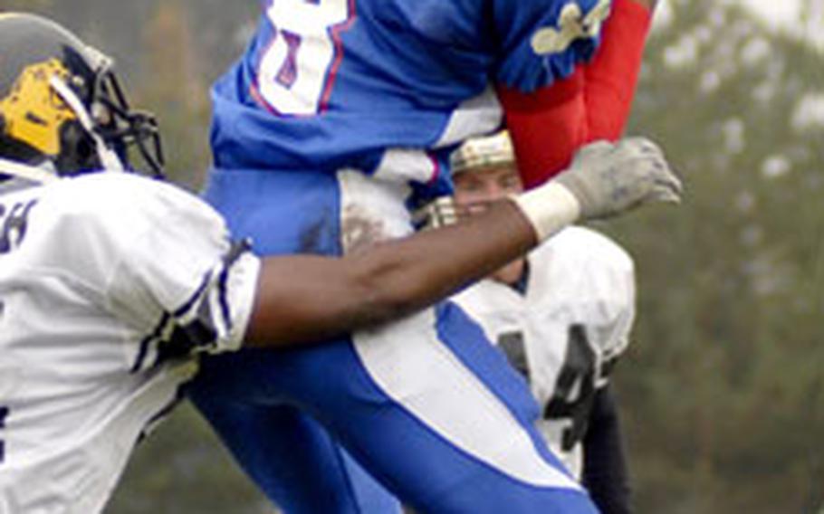 Ramstein Senior Ste’phan James leaps for a reception over Patch defender Brandon Bindley during Ramstein’s 41-20 victory over Patch.