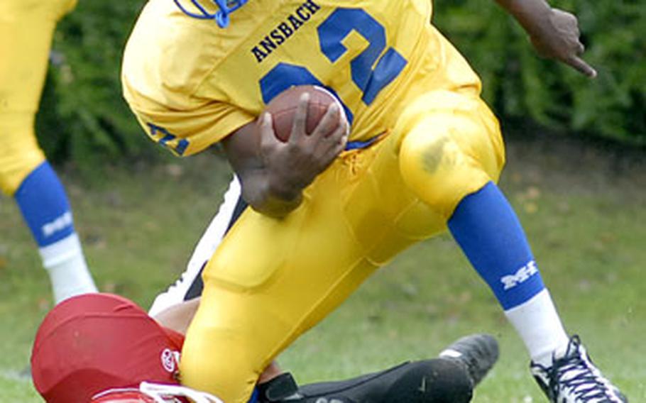 Ansbach’s Xavier Sheppard gets pulled down by Giessen’s Tim Fleming during Ansbach’s 39-0 victory on Saturday.  for more photos from Giessen’s final homecoming.