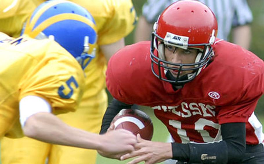 Giessen quarterback Brett Jones, right, looks for daylight against Ansbach’s Carter Gunn in Giessen’s 39-0 loss against the Cougars on Saturday.