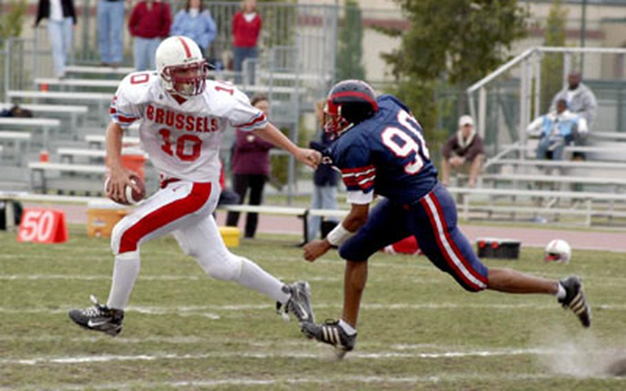 ISB quarterback Raphael Steege eludes Aviano’s Dante Rankin while trying to find time to complete a pass Saturday in Aviano, Italy.